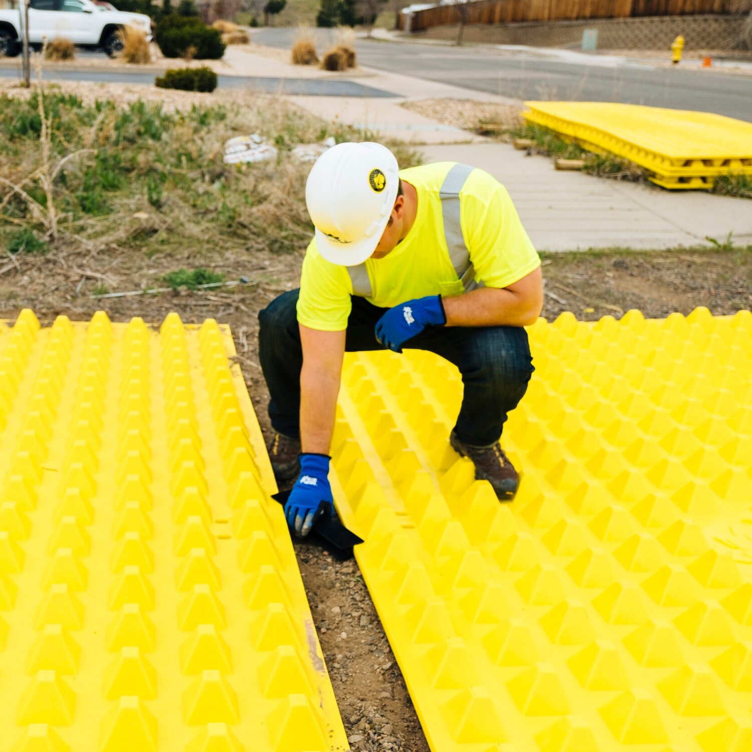 Person adding FODS tracking control mat H brackets in place