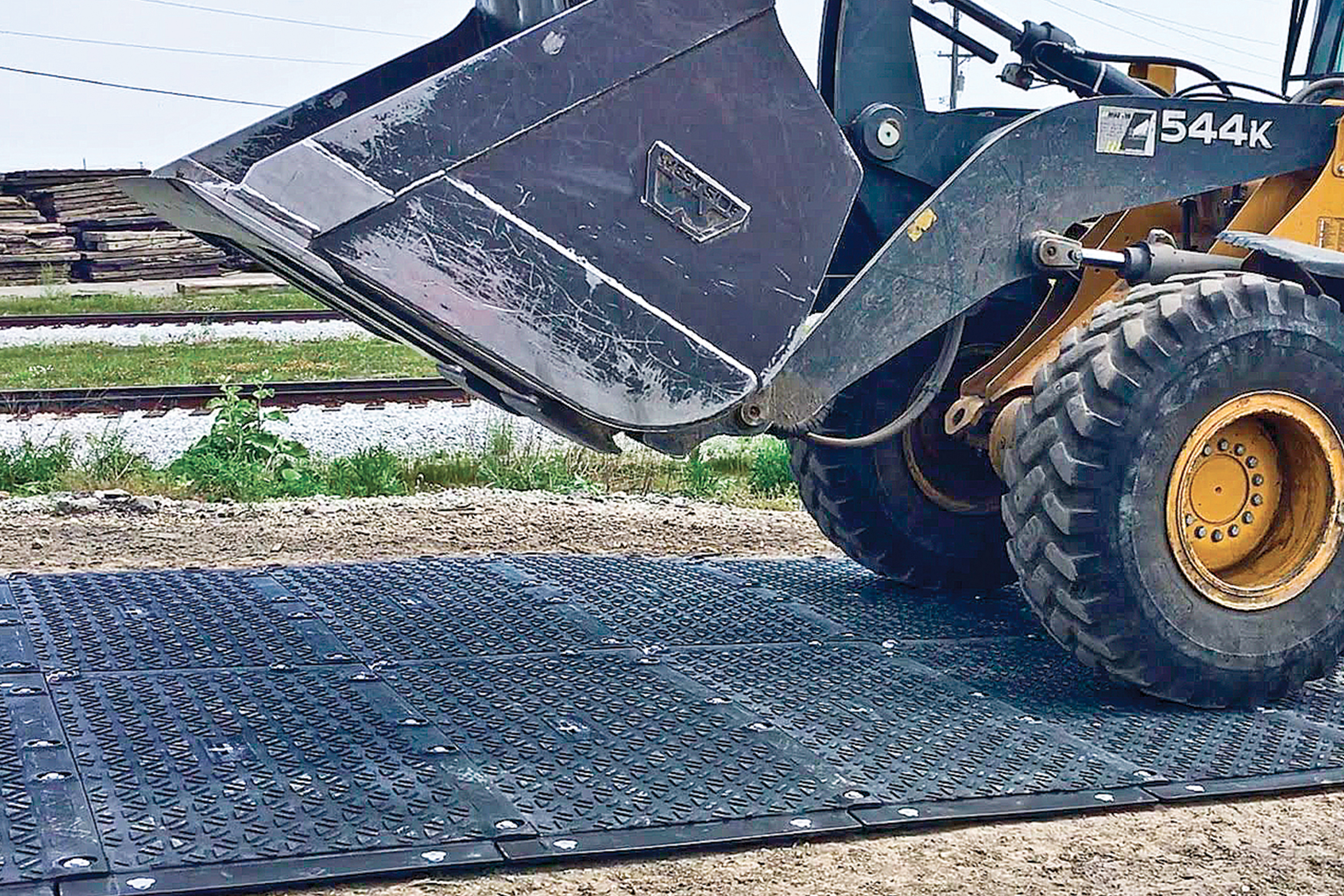 Backhoe loader using MaxiTrack ground mats