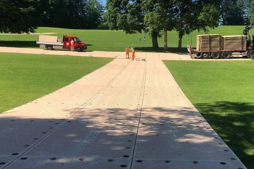 Workers assembling SignaRoad mats into a temporary road